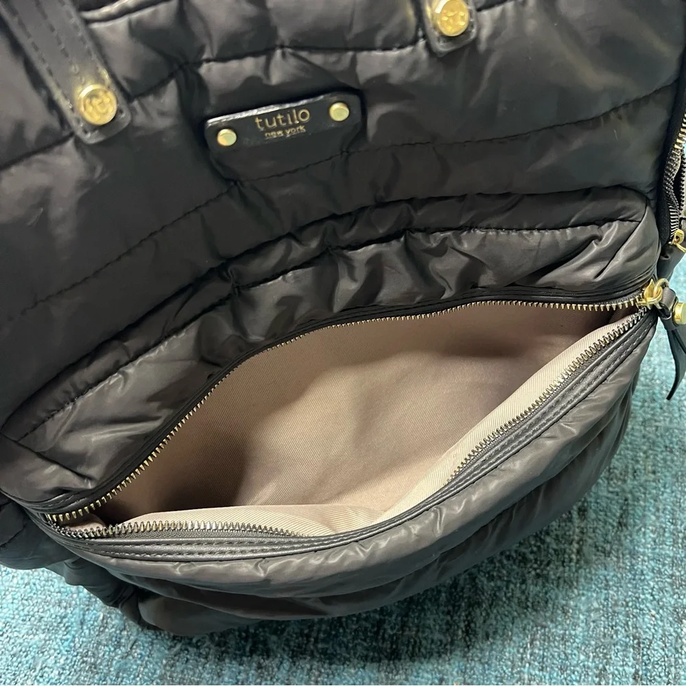Tutilo Travel Backpack in Black with Gold Quilted Luggage Trolley Sleeve Pocket
